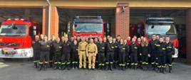 Na zdjęciu widać druhów OSP oraz naczelnika wydziału operacyjnego KP PSP w Oleśnie - st. kpt. Damiana Szczęsnego i
naczelnika wydziału ośrodka szkolenia KW PSP w Opolu - st. bryg. Wiesława Eliasza.
Wszyscy w ubraniach koszarowych na tle samochodów pożarniczych.
Zdjęcie wykonane na tle garażu Komendy Powiatowej PSP w Oleśnie.