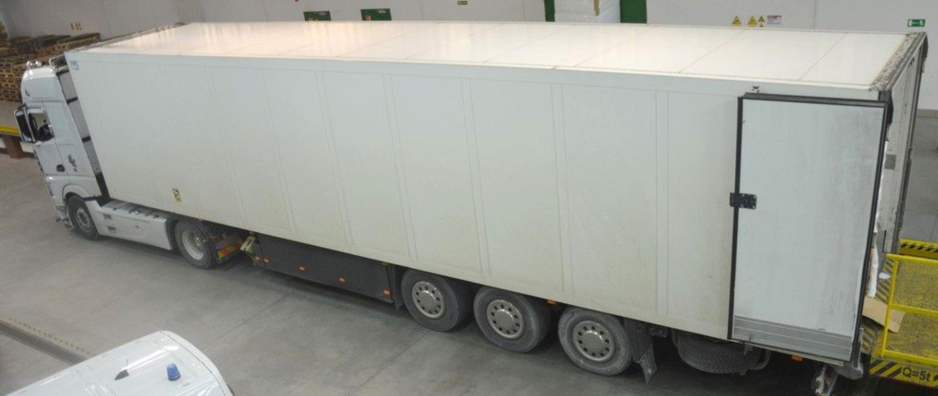 Zatrzymany samochód ciężarowy, bok radiowozu Służby Celno-Skarbowej.