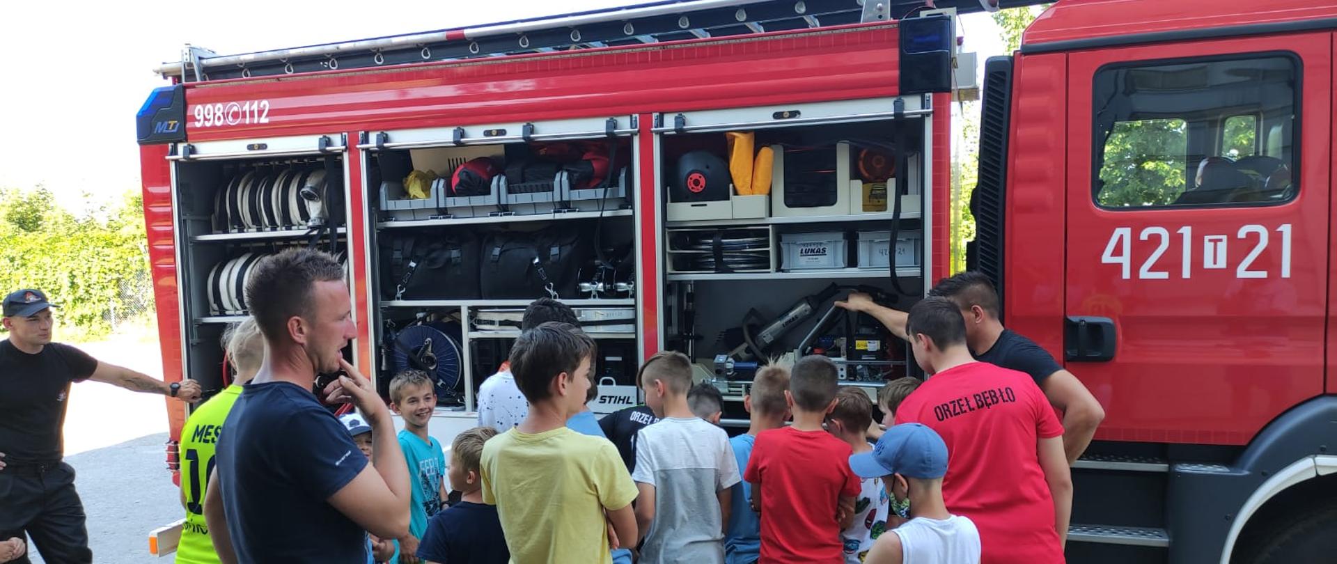 Strażacy omawiają i pokazują dzieciom sprzęt pożarniczy