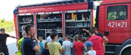Strażacy omawiają i pokazują dzieciom sprzęt pożarniczy