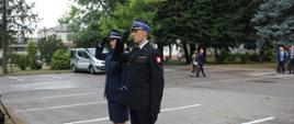 Funkcjonariusze PSP i Policji salutują po złożeniu wieńca.