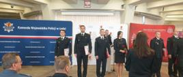 Stojący w szeregu nagrodzeni strażacy trzymający pamiątkowe dyplomy
