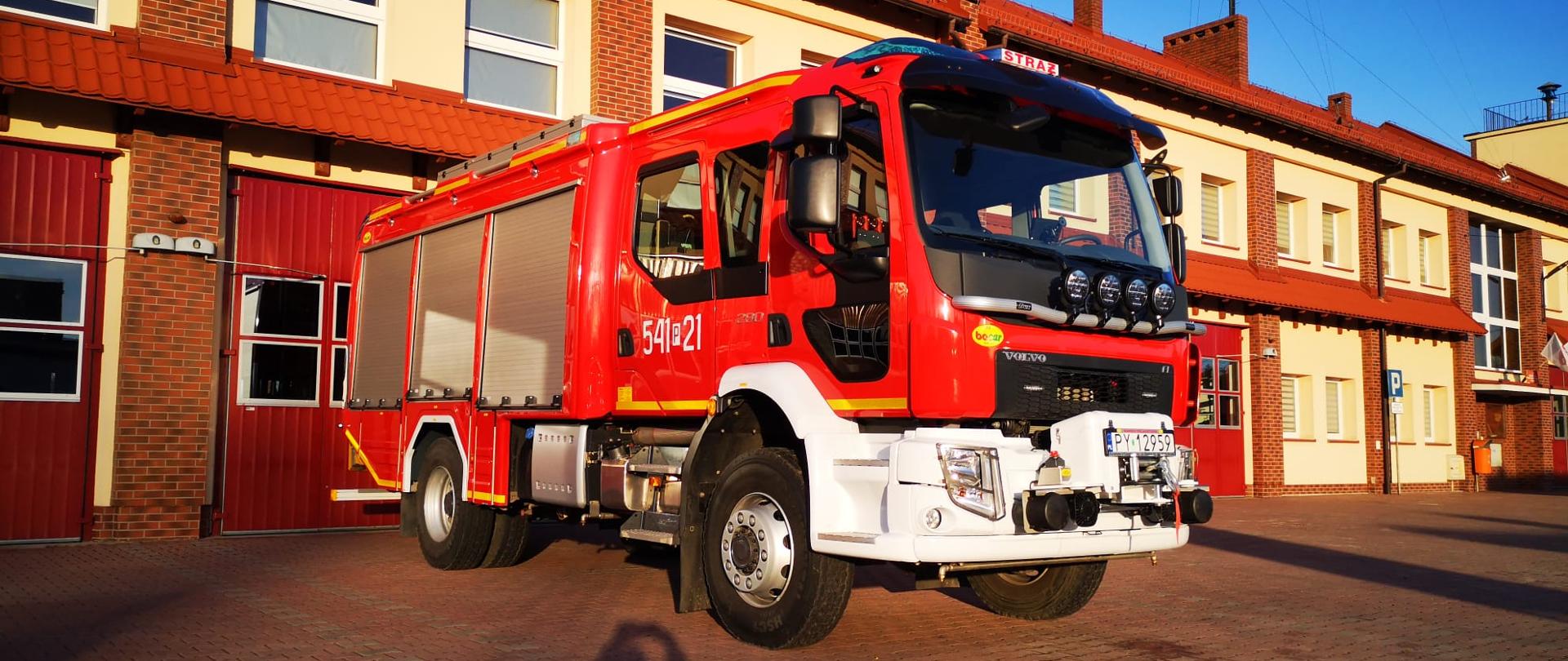 Na zdjęciu średni samochód gaśniczy marki VOLVO przed budynkiem Jednostki Ratowniczo-Gaśniczej