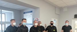 Strażacy oczekujący na szczepienie przeciw COVID-19 w ubraniach koszarowych. 