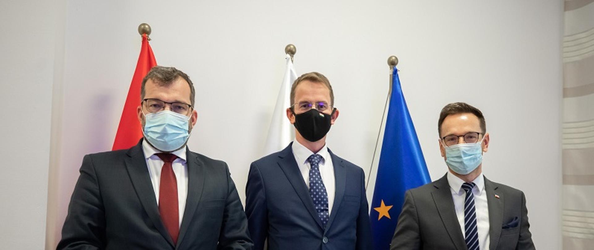 Od lewej minister Puda, w środku wiceminister z Węgier, po prawej wiceminister Buda. Panowie stoją na tle flag Polski, Węgier i Unii Europejskiej