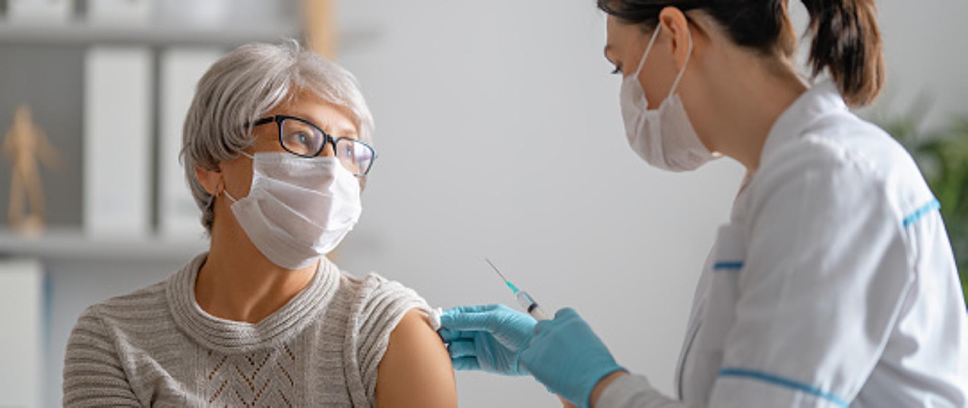 grafika przedstawia pielęgniarkę wykonującą zastrzyk starszej pani 