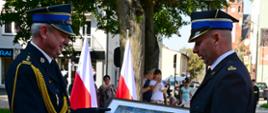 Komendant powiatowy Państwowej Straży Pożarnej w Lęborku wręcza pomorskiemu komendantowi wojewódzkiemu Państwowej Straży Pożarnej pamiątkowy obraz.