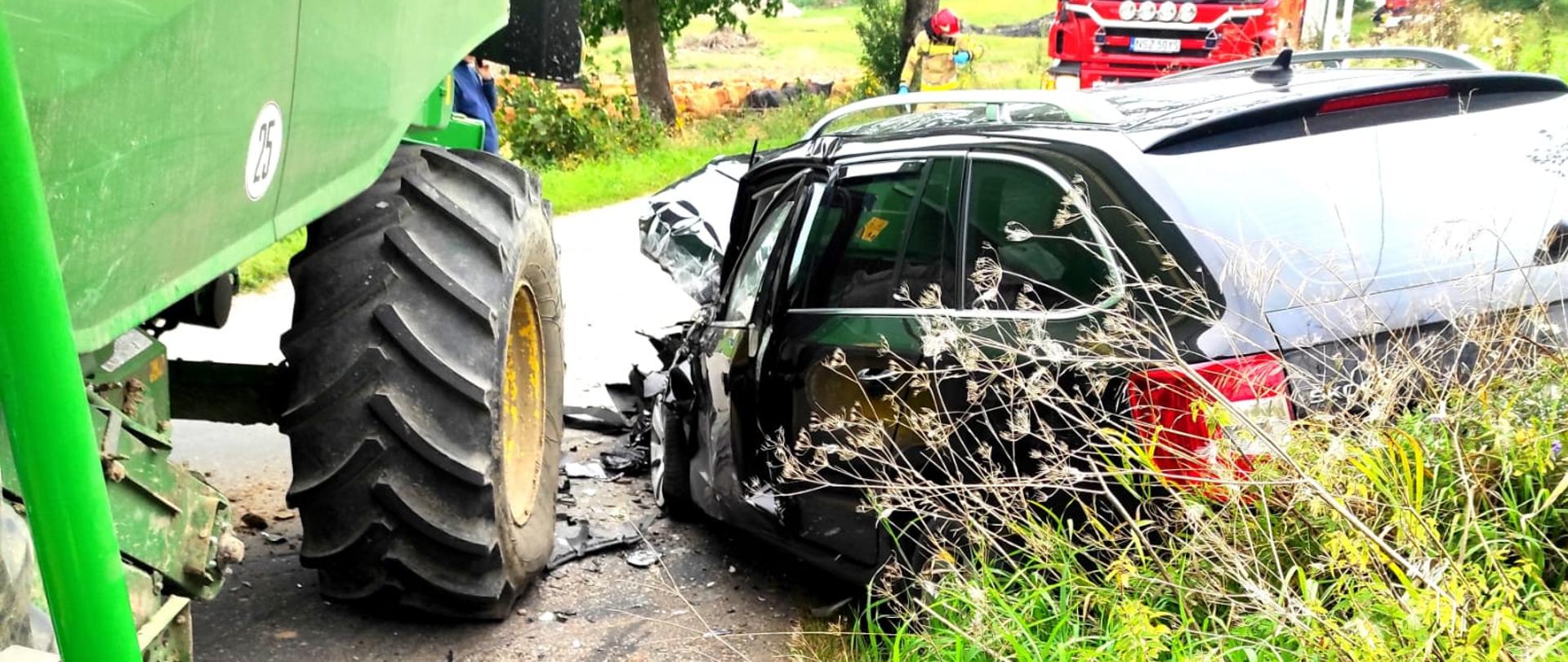 Zdjęcie przedstawia samochód osobowy po zderzeniu z kombajnem