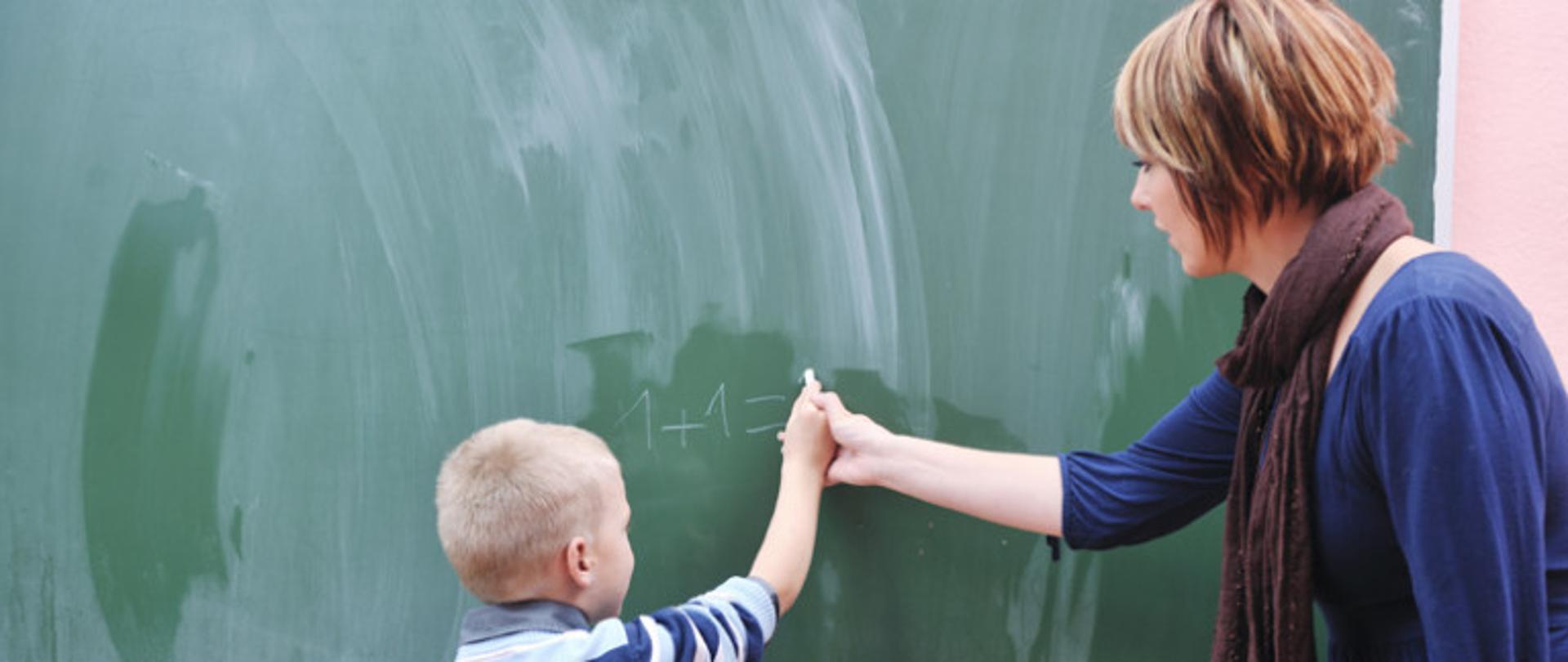 nauczyciel i uczeń przy tablicy