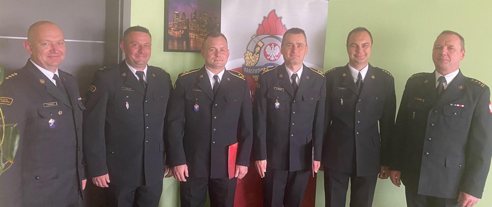 Zdjęcie ukazuje awansowanych funkcjonariuszy wraz ze swoimi przełożonymi