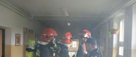 Strażacy na korytarzu w szkole
