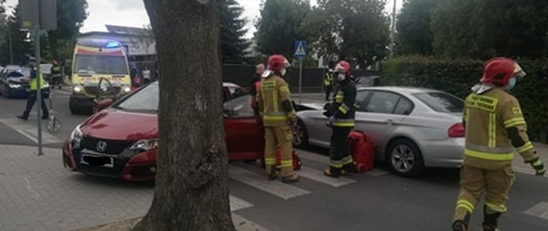 Strażacy udzielają pomocy podczas wypadku samochodowego