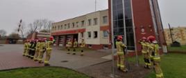 Zdjęcie przedstawia strażaków KP PSP w Wałczu w trakcie podnoszenia flagi państwowej na maszt