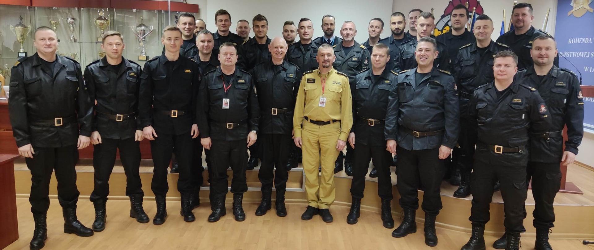 uczestnicy szkolenia oraz zastępca komendanta wojewódzkiego pozują do zdjęcia w sali konferencyjnej