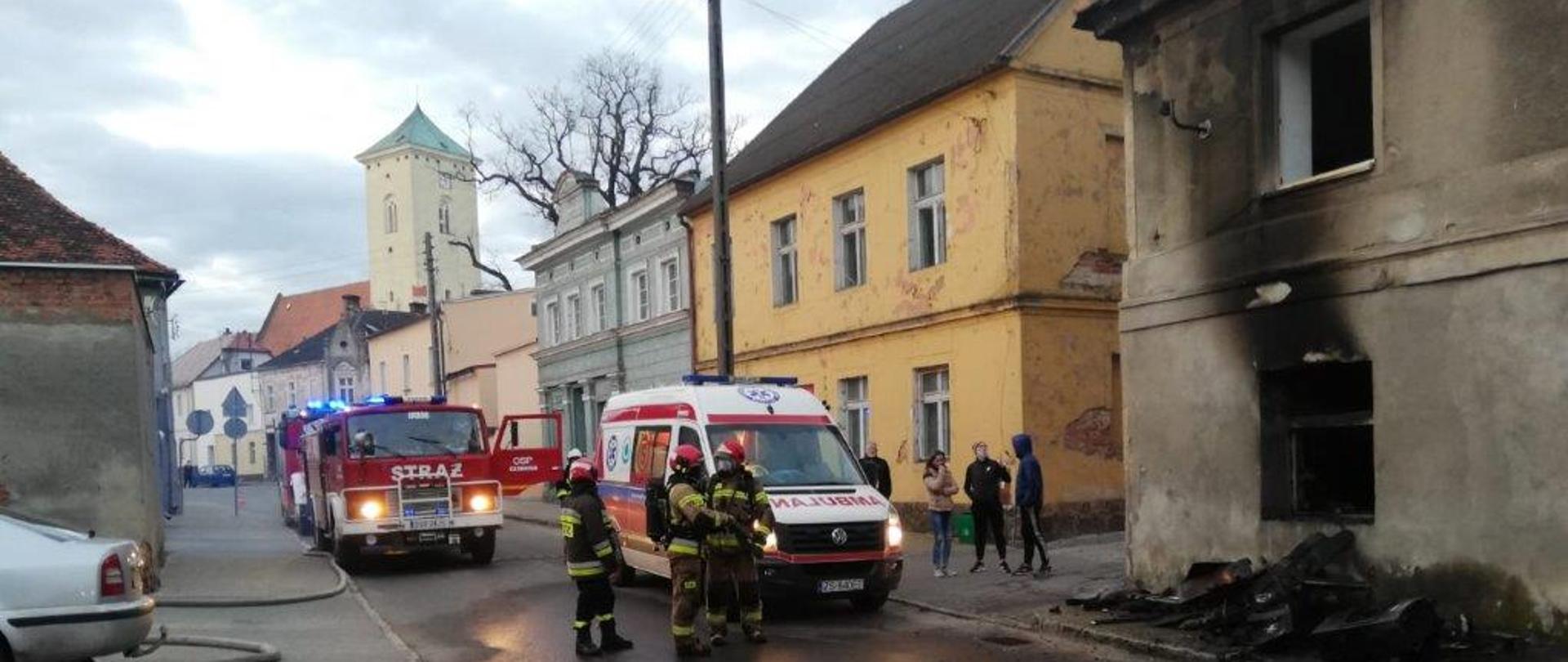 Na ulicy strażacy przed spalonym do mem