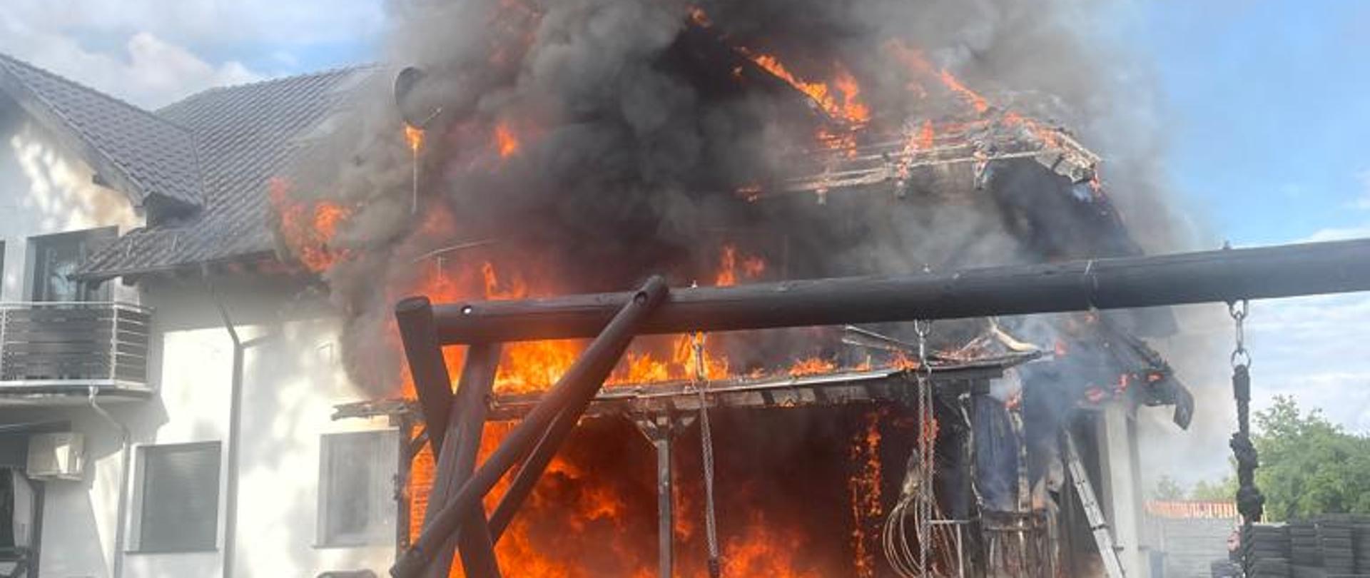 widok rozwiniętej fazy pożaru połowy budynku dwurodzinnego. budynek cały w ogniu.
