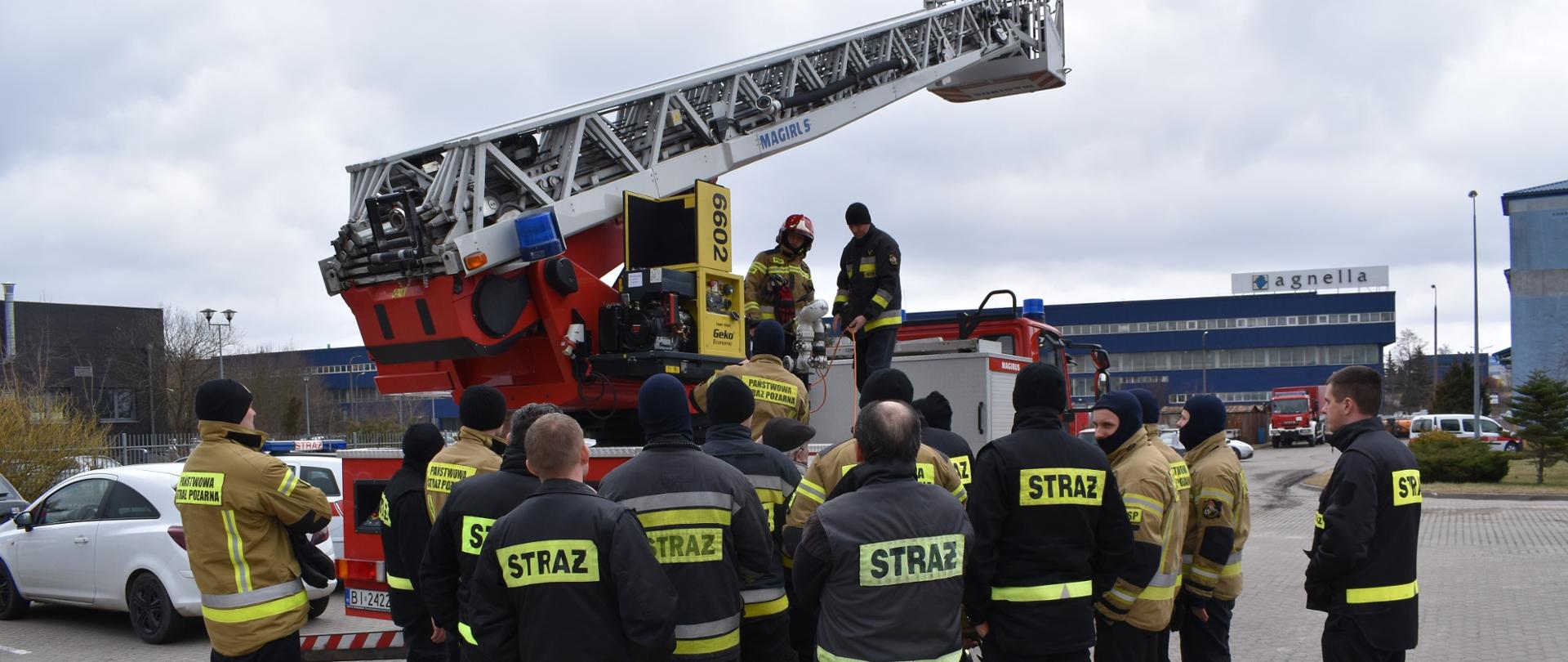 Zdjęcie przedstawia funkcjonariuszy podczas szkolenia z obsługi drabin mechanicznych