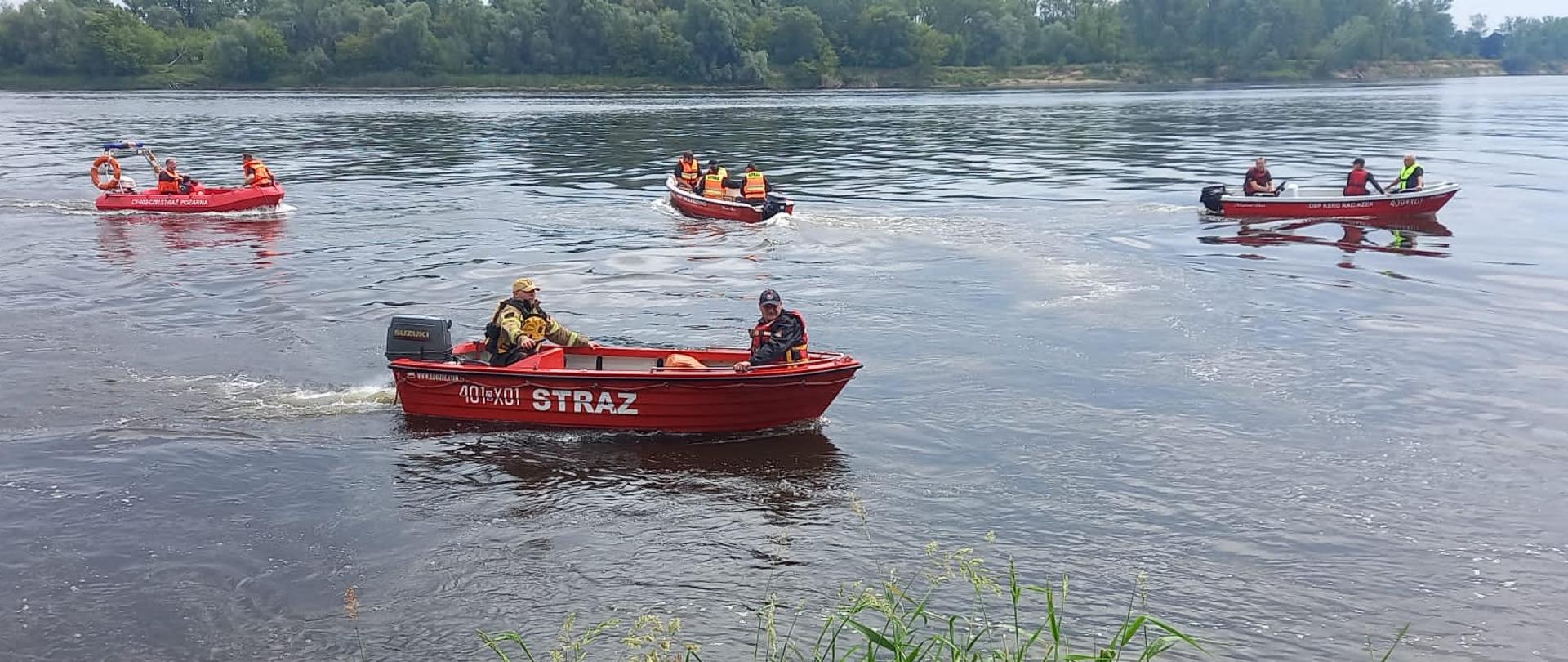 cztery lodzie strażackie wraz ze strażakami podczas ćwiczeń z zakresy ratownictwa wodnego na rzece Wisła