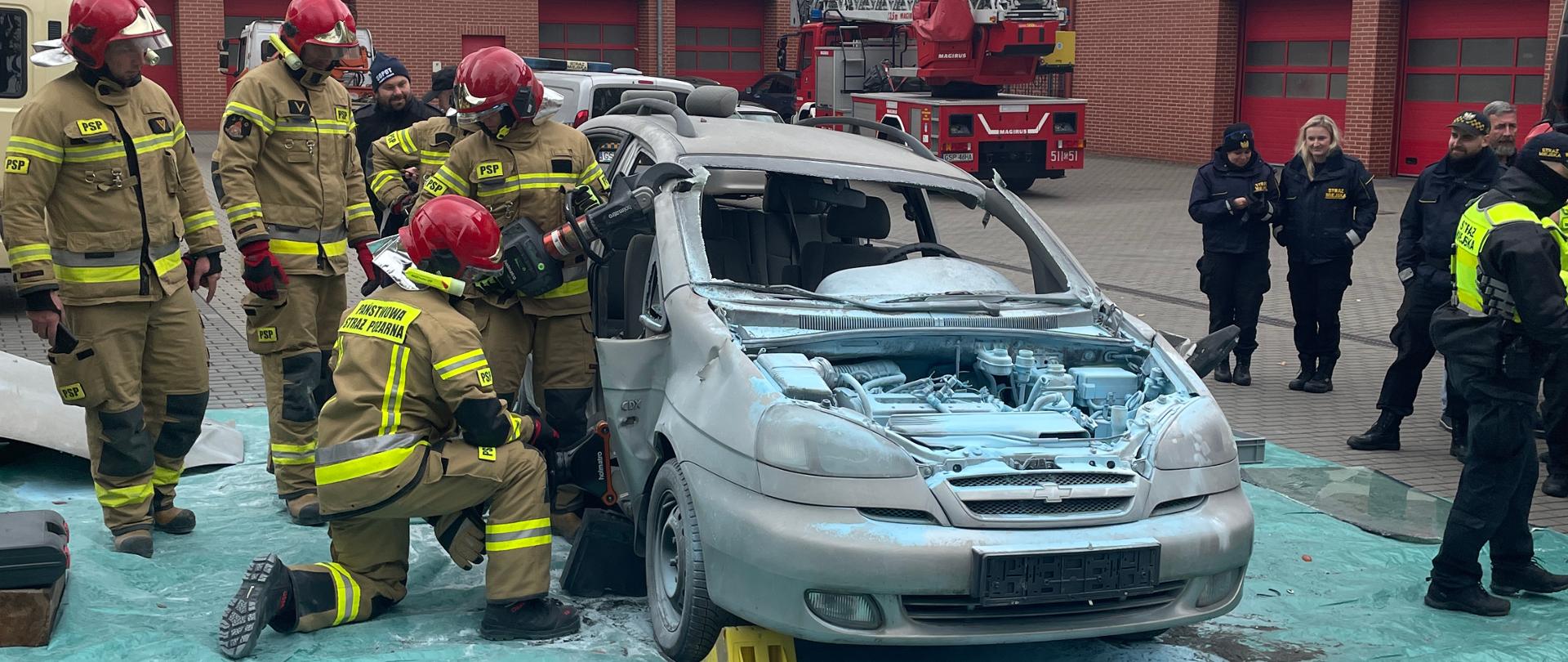 Strażacy ćwiczą użycie sprzętu hydraulicznego na samochodzie