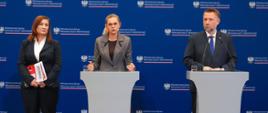 Ministra Edukacji Barbara Nowacka przemawia przy mównicy. Po jej lewej stronie stoi Podsekretarz Stanu Paulina Piechna-Więckiewicz, a po prawej Minister Spraw Wewnętrznych i Administracji Marcin Kierwiński na tle ścianki z logo MSWiA.