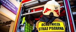 Strażak Ochotniczej Straży Pożarnej przy samochodzie ratowniczo-gaśniczym przygotowuje sprzęt do działań ratowniczych.