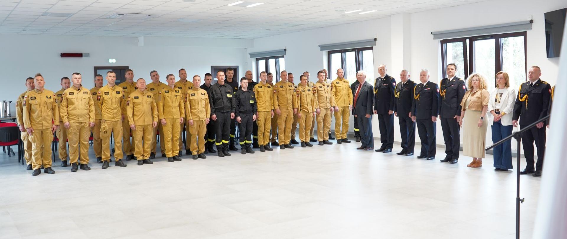 Na zdjęciu widnieją strażacy w trakcie uroczystej zbiórki z okazji Dnia Strażaka. 