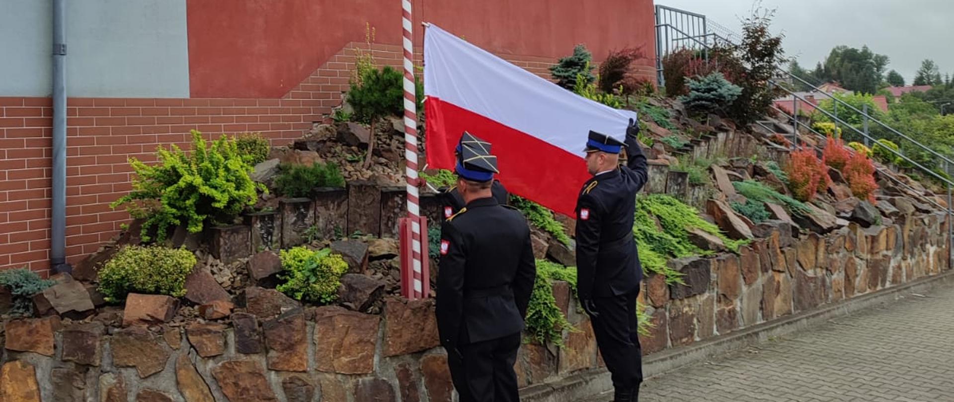Zdjęcie przedstawia uroczystą zbiórkę z okazji podniesienia flagi państwowej. Na pierwszym planie poczet flagowy podczas podnoszenia flagi.