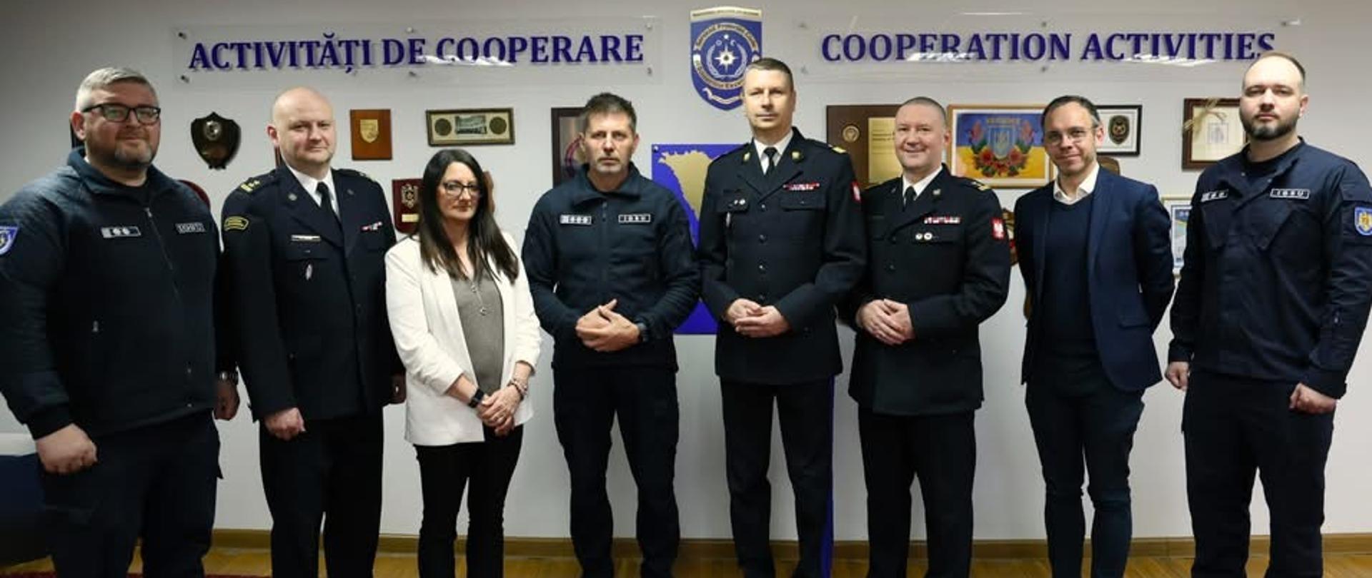Grupa przedstawicieli służb ratowniczych i instytucji stoi do wspólnego zdjęcia na tle tablicy z napisem „Cooperation Activities”.