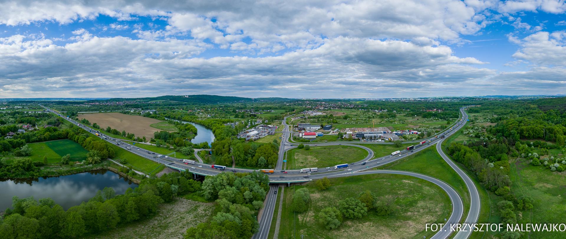 A4 Balice - Kraków Południe, węzeł Kraków Tyniec, w pobliżu węzła zabudowania przemysłowe, po lewej starorzecze Wisły, w oddali Klasztor w Bielanach
