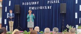 Państwowy Powiatowy Inspektor Sanitarny w Garwolinie przemawia na scenie - napis w tle "Ekologiczny piknik rodzinny"