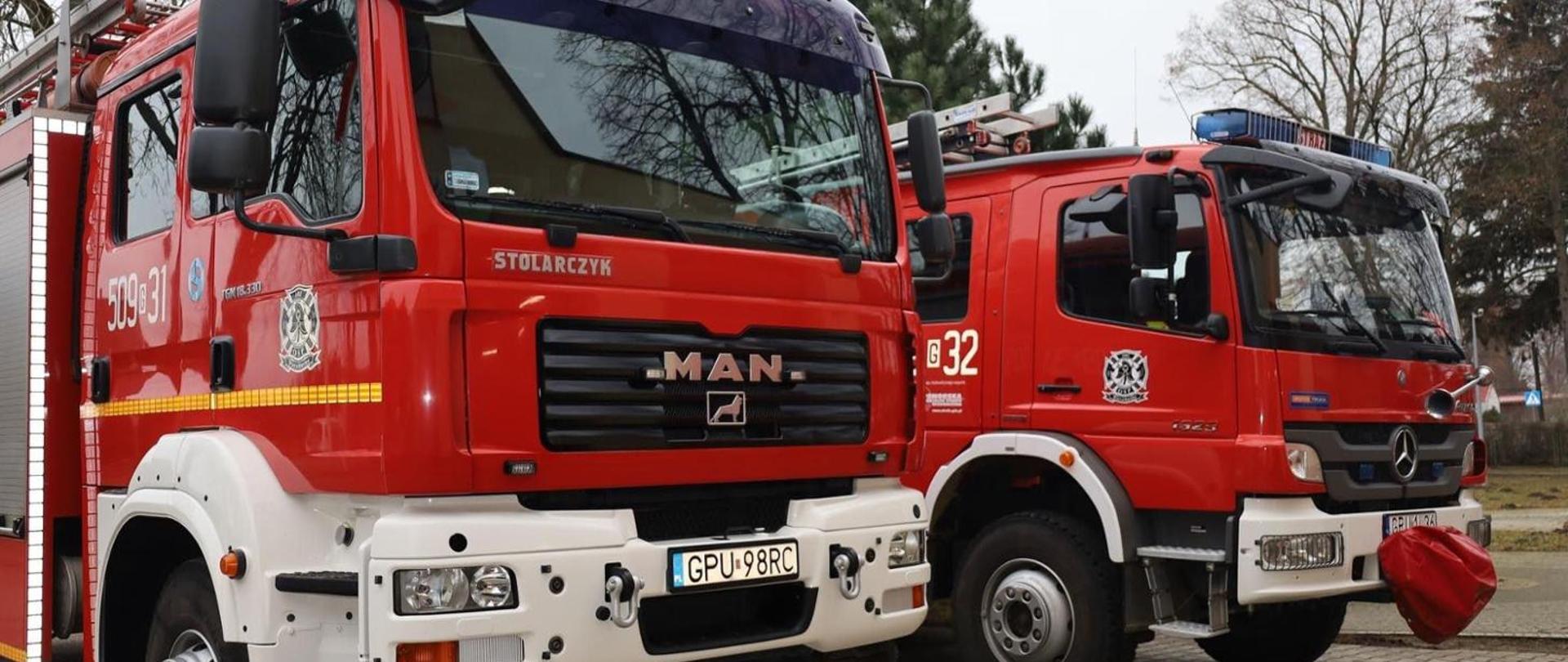 Zdjęcie przedstawia dwa obok siebie stojące samochody ratowniczo-gaśnicze