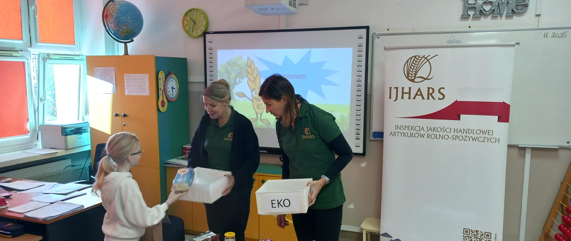 Inspektorki IJHARS prowadzą prezentację w klasie, w tle widoczne jest logo IJHARS