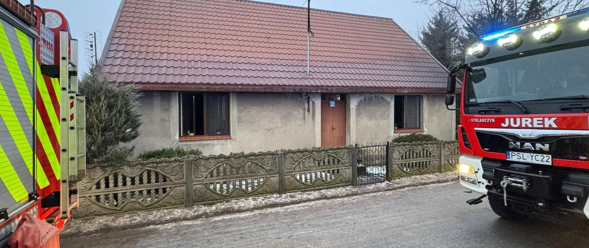 samochody pożarnicze oraz budynek w którym powstał pożar