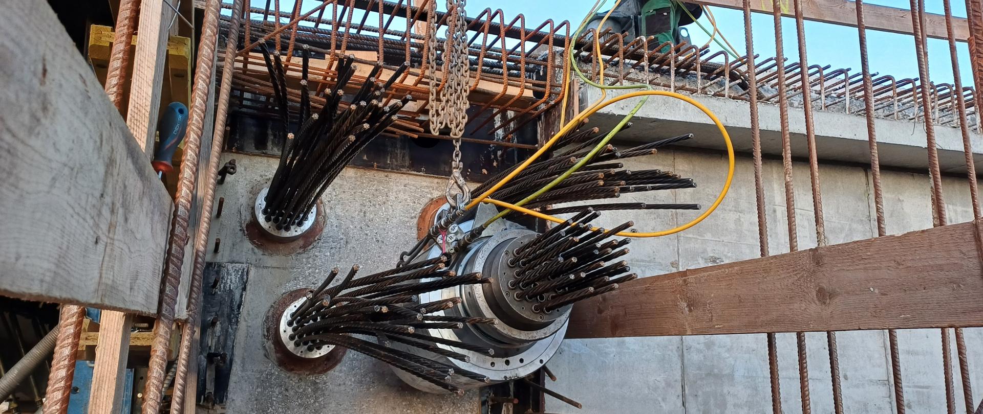 Zdjęcie wnętrza budowanej estakady w ciągu drogi ekspresowej S19. Widoczne elementy ze stalowych kabli przechodzące przez wnętrze, wzdłuż betonowej estakady. U góry elementy zbrojenia przygotowane do zalania kolejną warstwą betonu.