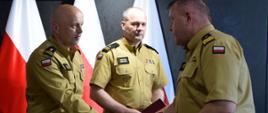 Podkarpacki komendant wojewódzki wręcza akt powołania bryg. Pawłowi szkole. strażacy w mundurach