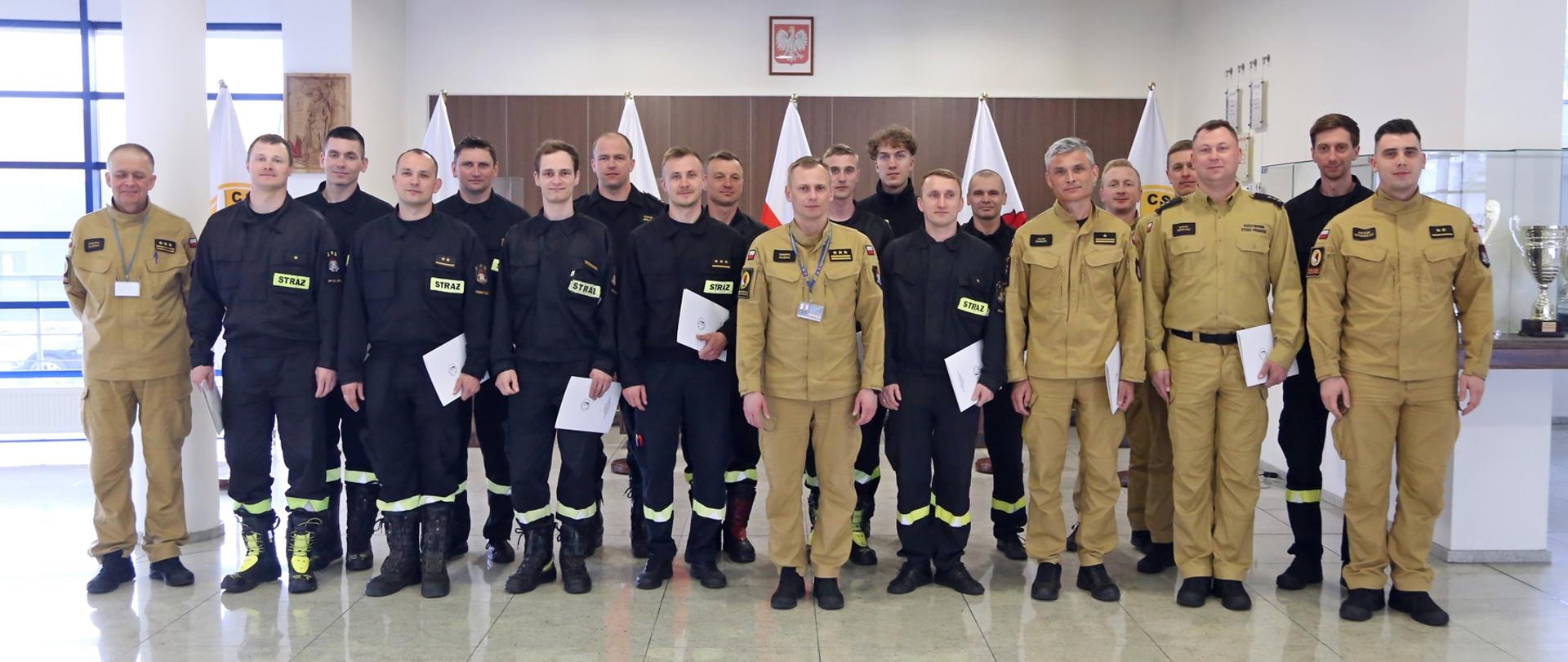 Grupowe zdjęcie uczestników szkolenia (16 funkcjonariuszy PSP) w towarzystwie Zastępcy Komendanta Centralnej Szkoły PSP oraz trzech funkcjonariuszy CS PSP