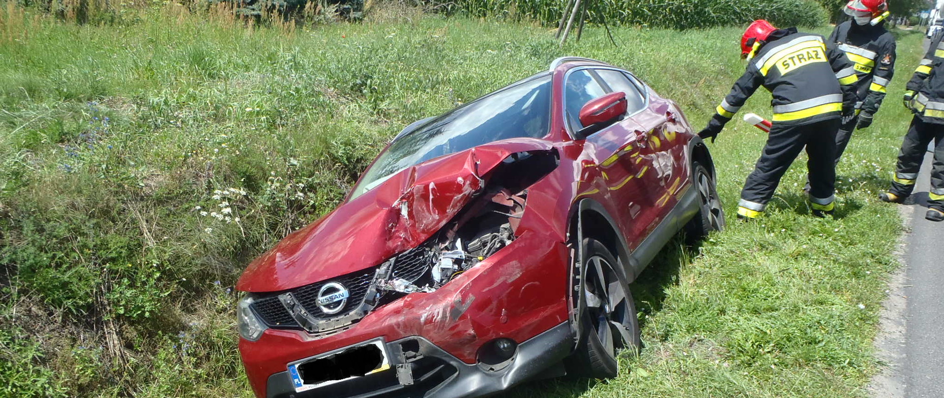 w rowie stoi przechylony rozbity czerwony suw z boku strażacy 