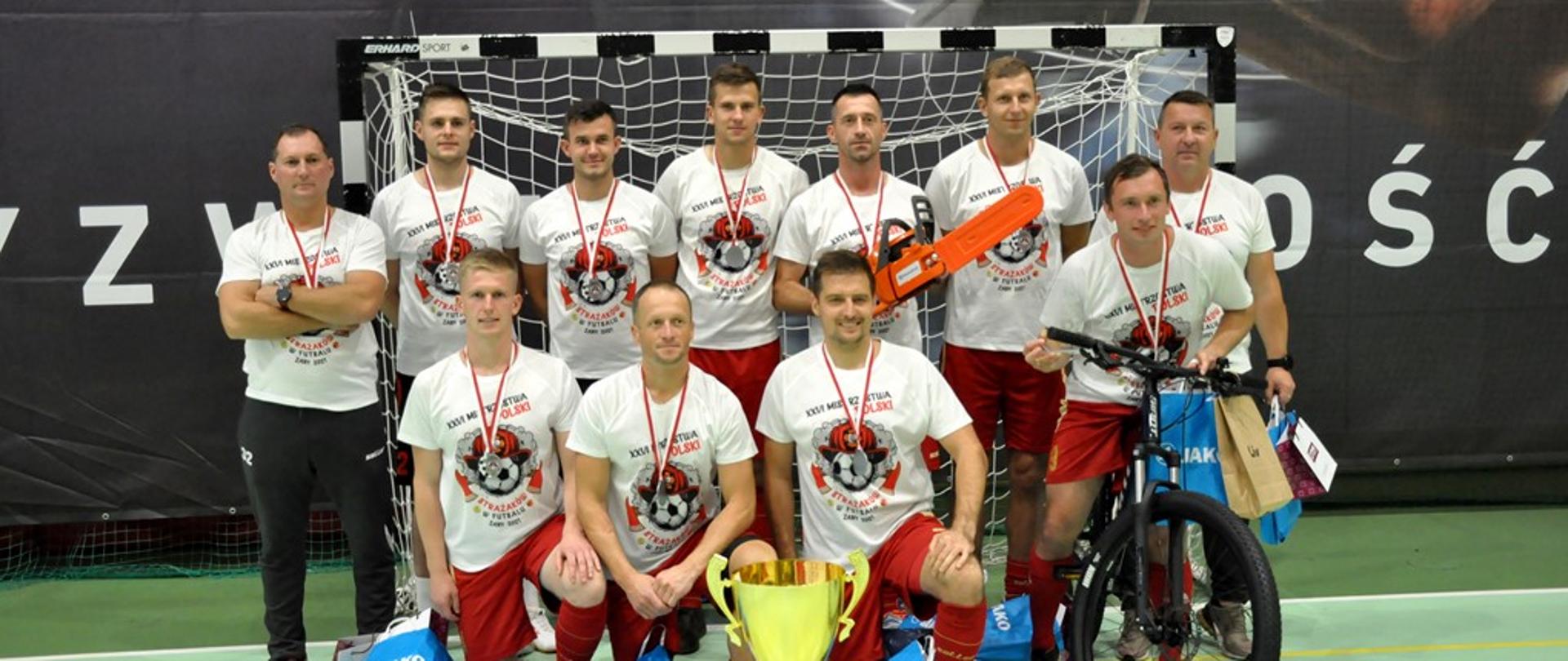 Drużyna województwa zachodniopomorskiego na tle bramki do futsalu. Wraz z nagrodami oraz pucharem za zajęcie 2 miejsca