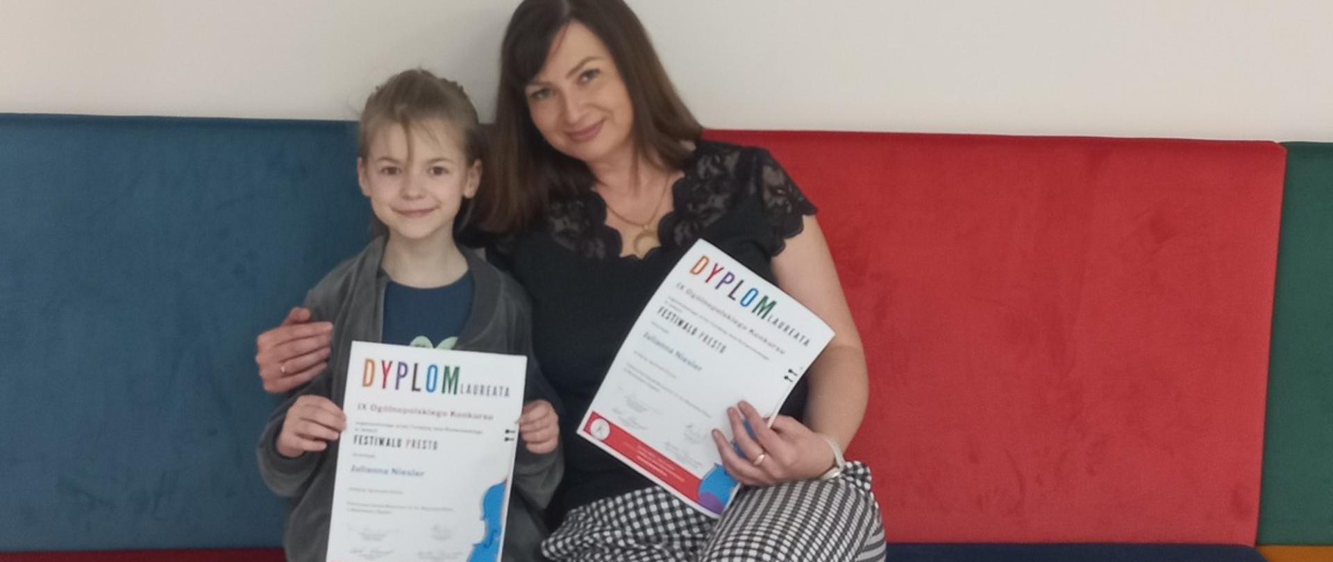 Uczennica wraz z nauczycielką prezentują dyplom