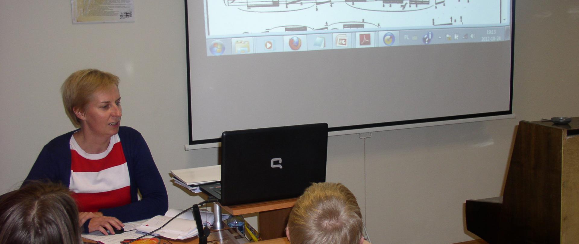 Uczniowie i nauczyciel na zajęciach audycji muzycznych