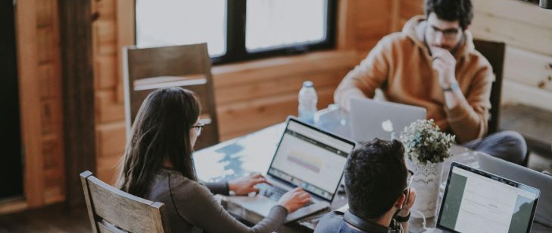 Ludzie siedzą przy stole i pracują