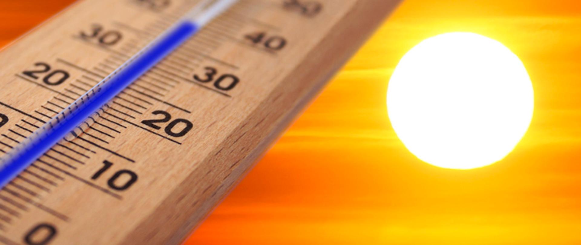 Na obrazku widzimy termometr ze wskazaniem temperatury powyżej 30 stopni Celsjusza oraz Słońce na pomarańczowym tle