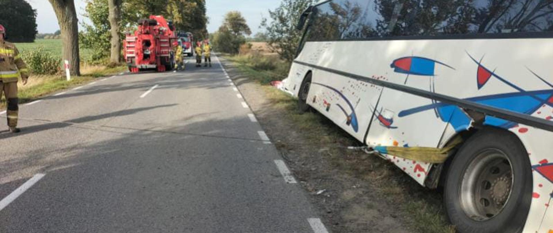 Na zdjęciu widzimy autokar oraz strażaków z Specjalistycznej Grupy Ratownictwa Technicznego z JRG Tczew, którzy wyciągają go z rowu z wykorzystaniem wyciągarek.