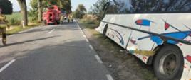 Na zdjęciu widzimy autokar oraz strażaków z Specjalistycznej Grupy Ratownictwa Technicznego z JRG Tczew, którzy wyciągają go z rowu z wykorzystaniem wyciągarek.