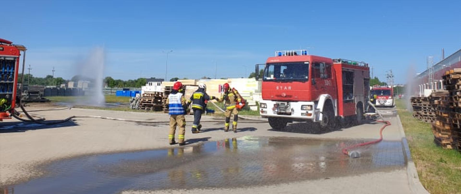 Strażacy z JRG Oborniki oraz OSP KIszewo i Rożnowo podczas działań ratowniczo gaśniczych na terenie DT Swiss podczas działań ratowniczo gaśniczych. Na pierwszym planie KDR - kierujący działaniem ratowniczym oraz strazak z OSP i PSP. W tle samochod pożarniczy z JRG Oborniki. 