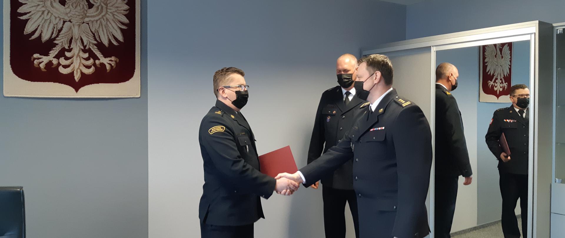 Zdjęcie przedstawia Zastępcę Komendanta Wojewódzkiego PSP st. bryg. mgr inż. Roberta Tadeusza Dzierżek dziękującego za wieloletnią służbę Zastępcy Komendanta Miejskiego PSP st. bryg dr inż. Tomasza Gierasimiuka