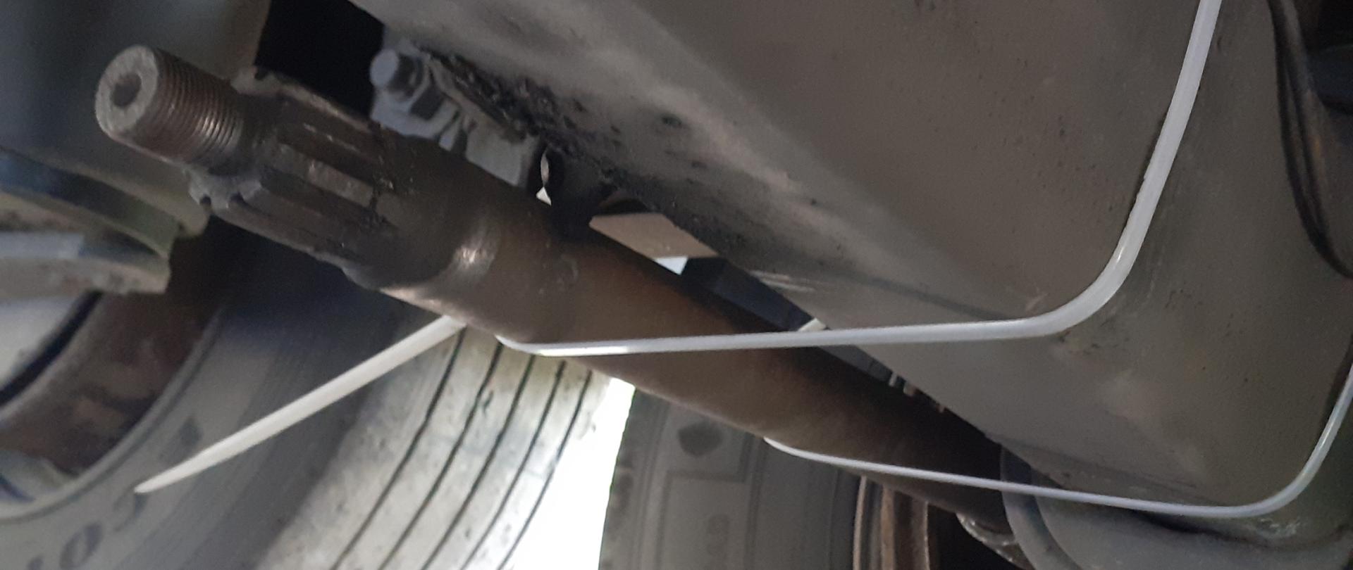 Odłączony przewód układu pneumatycznego od siłownika hamulcowego przy jednym z kół naczepy ciężarowej.