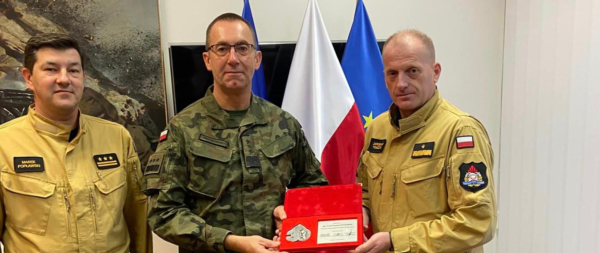 Wizyta w DO RSZ, na zdjęciu widoczni Zachodniopomorski Komendant Wojewódzki Państwowej Straży Pożarnej w Szczecinie nabryg. Jarosław Tomczyk oraz jego Zastępca - st. bryg. Marek Popławski. Wręczają Oni medal pamiątkowy z okazji XXX lecia PSP dla gen. broni Tomasza Piotrowskiego.