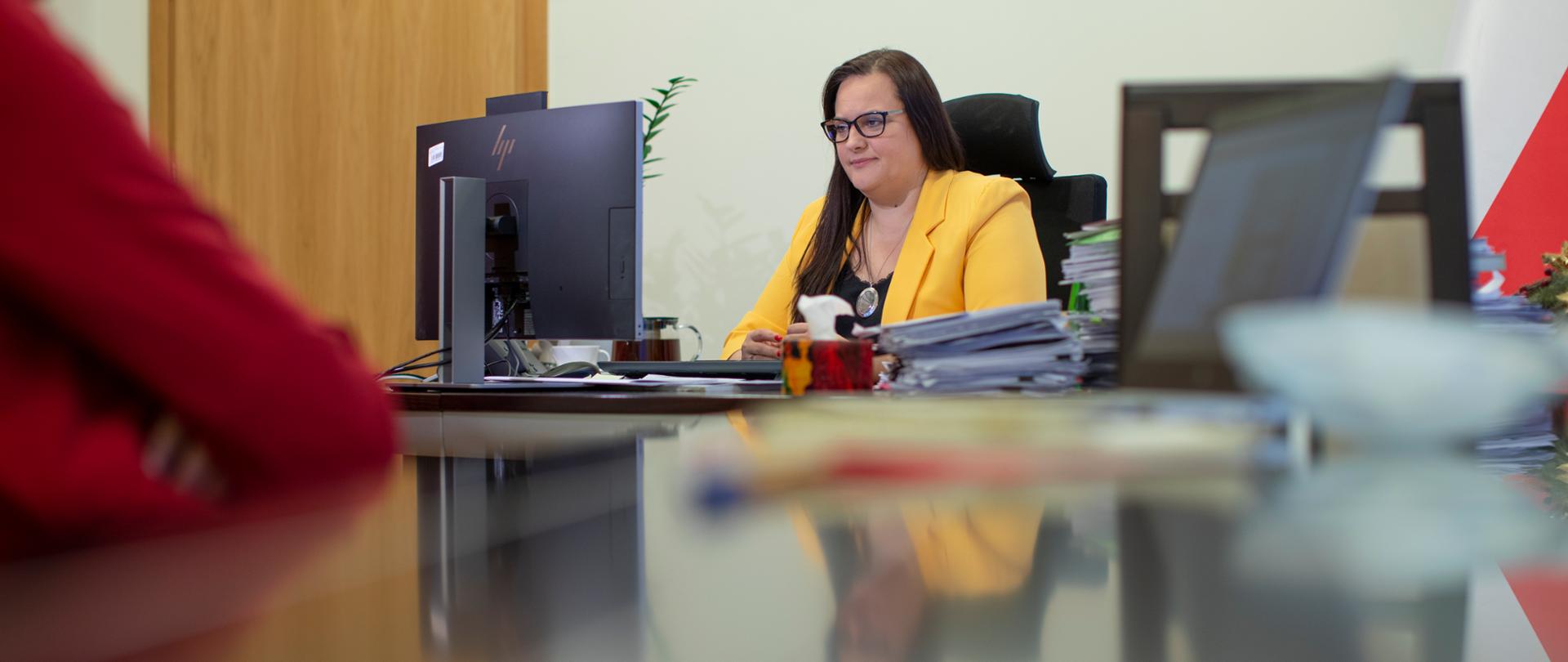 Minister Jarosińska-Jedynak siedzi przy biurku