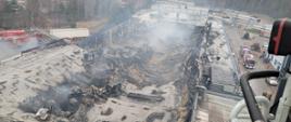Zawalony dach po pożarze hali, widok z góry, pora dzienna